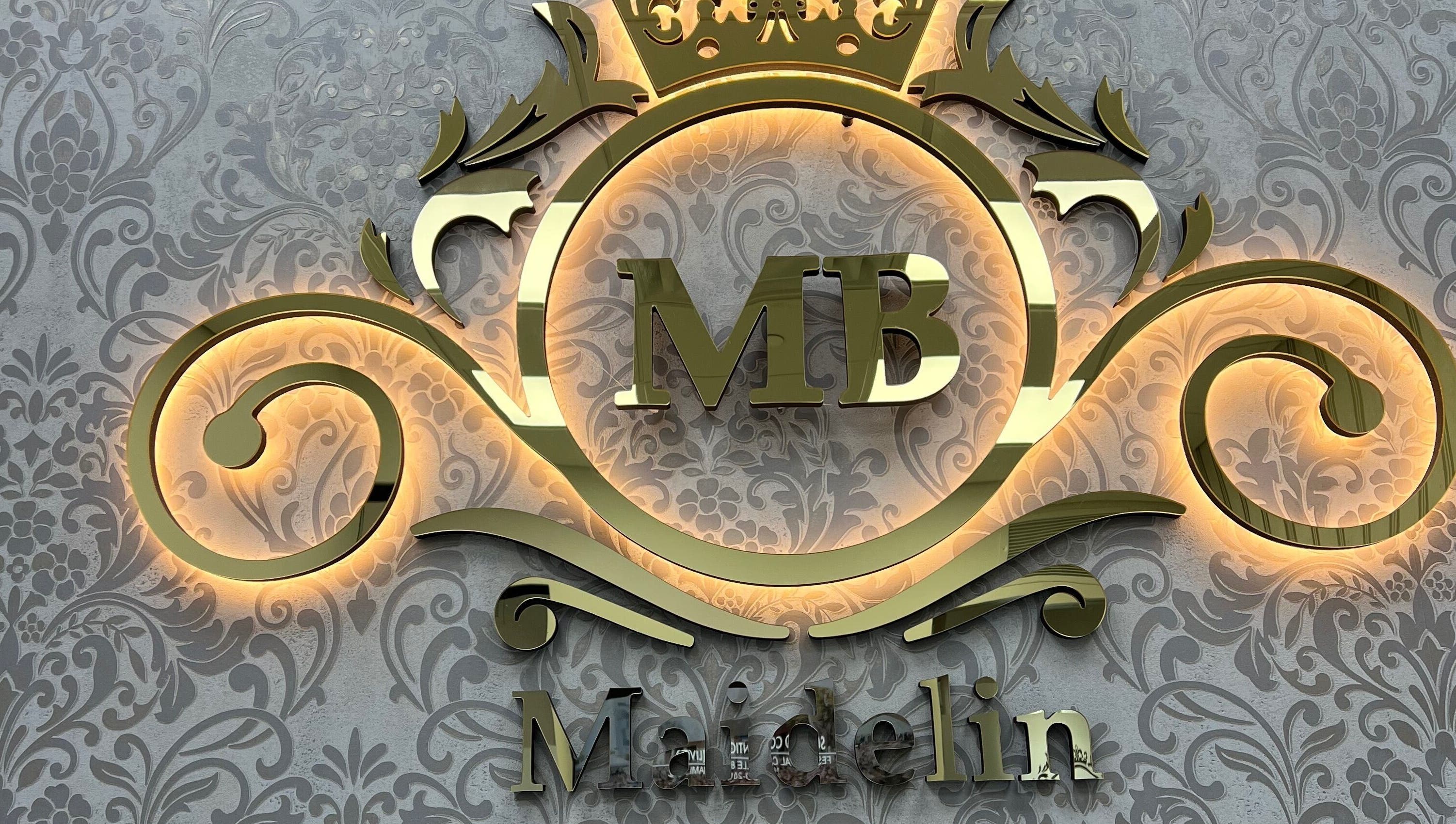 Golden ornate logo of MAIDELIN BEAUTY & SPA in Miami, Florida, US, on a decorative background.