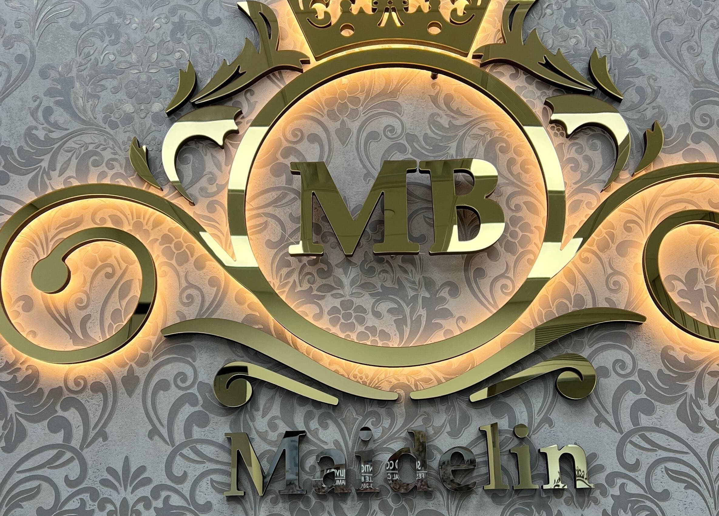 Golden ornate logo of MAIDELIN BEAUTY & SPA in Miami, Florida, US, on a decorative background.