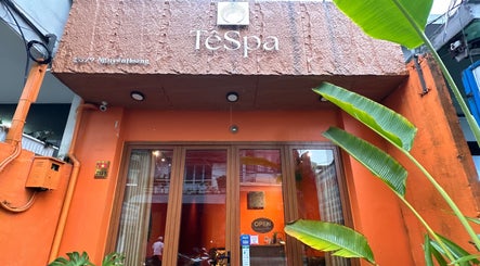 Entrance of Tê Spa in Đà Nẵng, showcasing vibrant exterior with green foliage accents.
