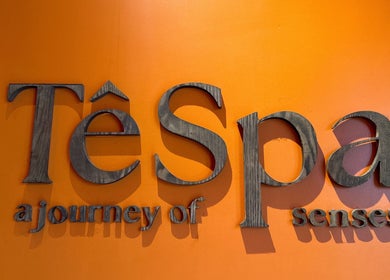 Tê Spa entrance sign in Đà Nẵng, VN, with soothing orange backdrop and elegant lettering.