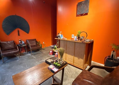 Welcoming reception area of Tê Spa in Đà Nẵng, Đà Nẵng, VN, with vibrant orange walls and cozy seating.