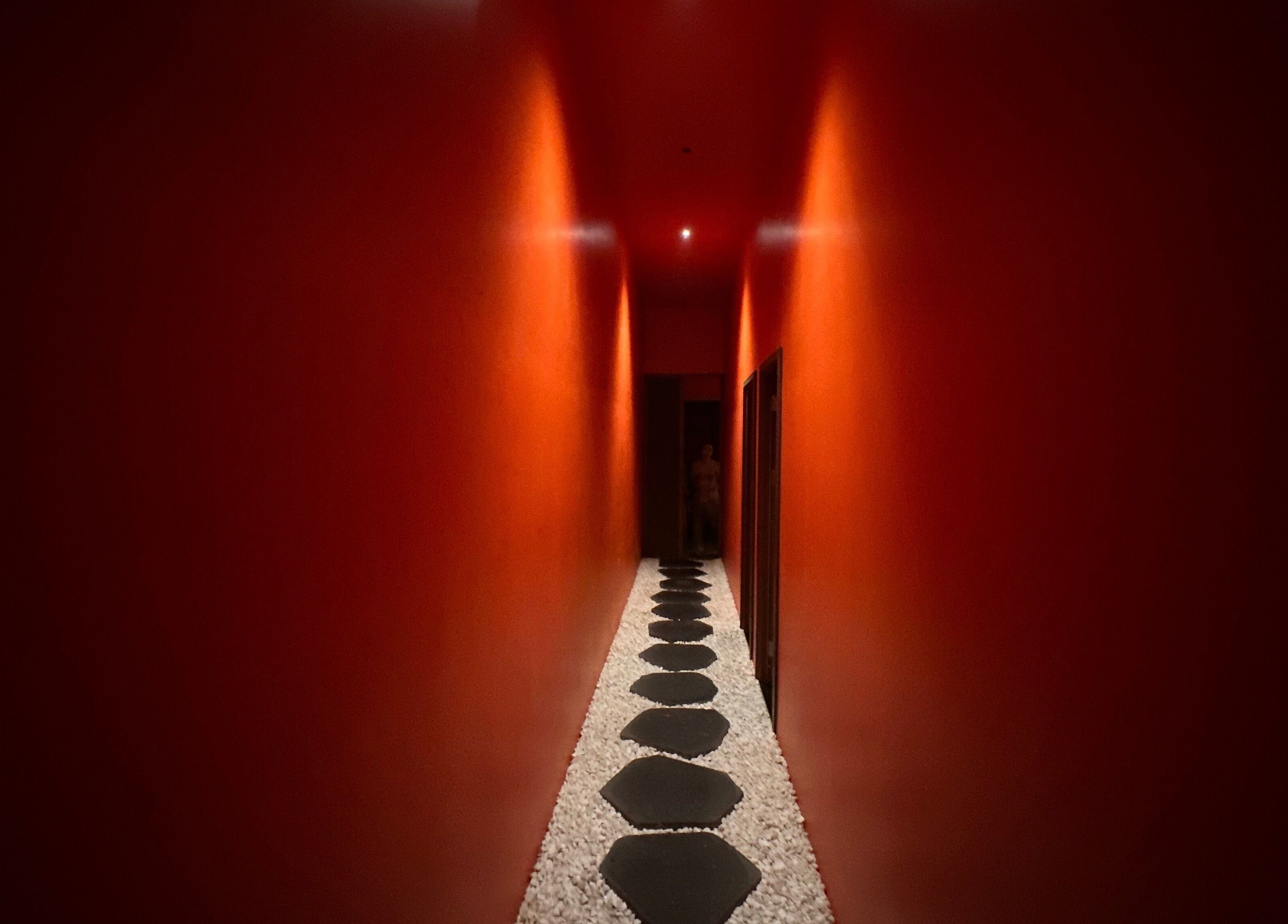 Tranquil red corridor with pebble path at Tê Spa, Đà Nẵng, Đà Nẵng, VN.