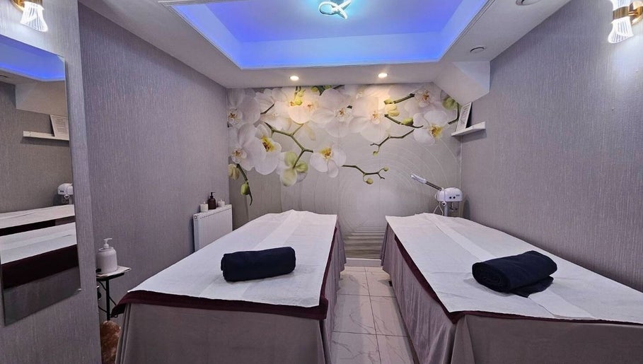 Tranquil massage room at Healthlan Massage & Spa, London, England, GB with orchid decor and twin tables.
