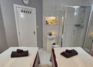 Relaxing massage room at Healthlan Massage & Spa, London, England, GB with twin tables and calming ambiance.