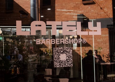 Front window of Rocky - Lately Barbershop in Bowden, South Australia, AU with logo and QR code.