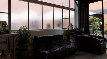 Cozy lounge area at Rocky - Lately Barbershop, Bowden, South Australia, AU with plants and modern seating.