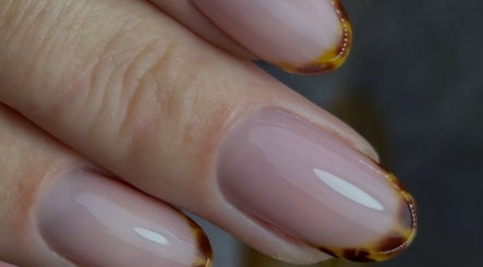 Elegant nail art at Gnb Nail Studio in Broomfield, England, GB featuring glossy pink nails with brown accents.