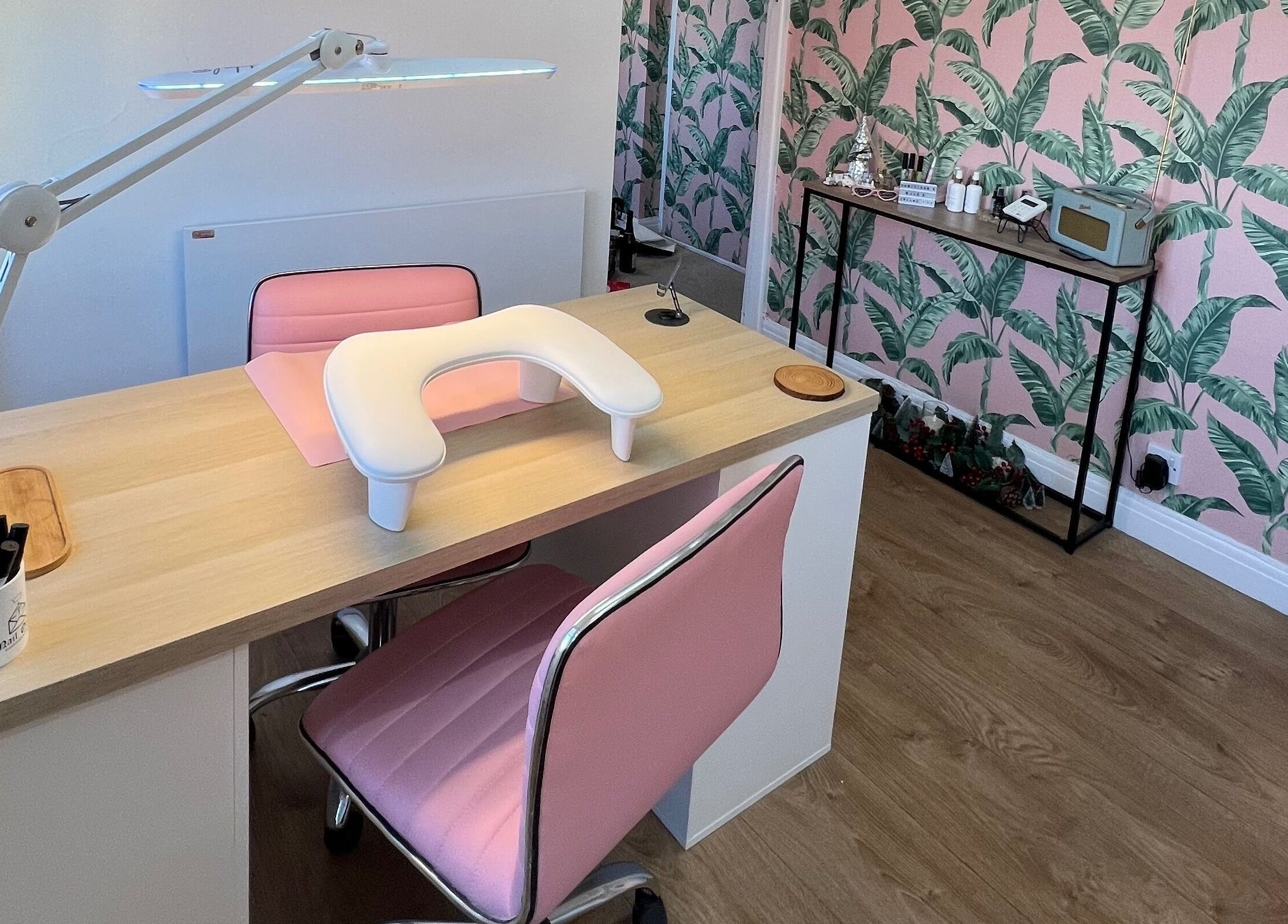 Modern manicure station at Rockets Nails by Vicki, Beverley, England, GB with pink decor and tropical wallpaper.