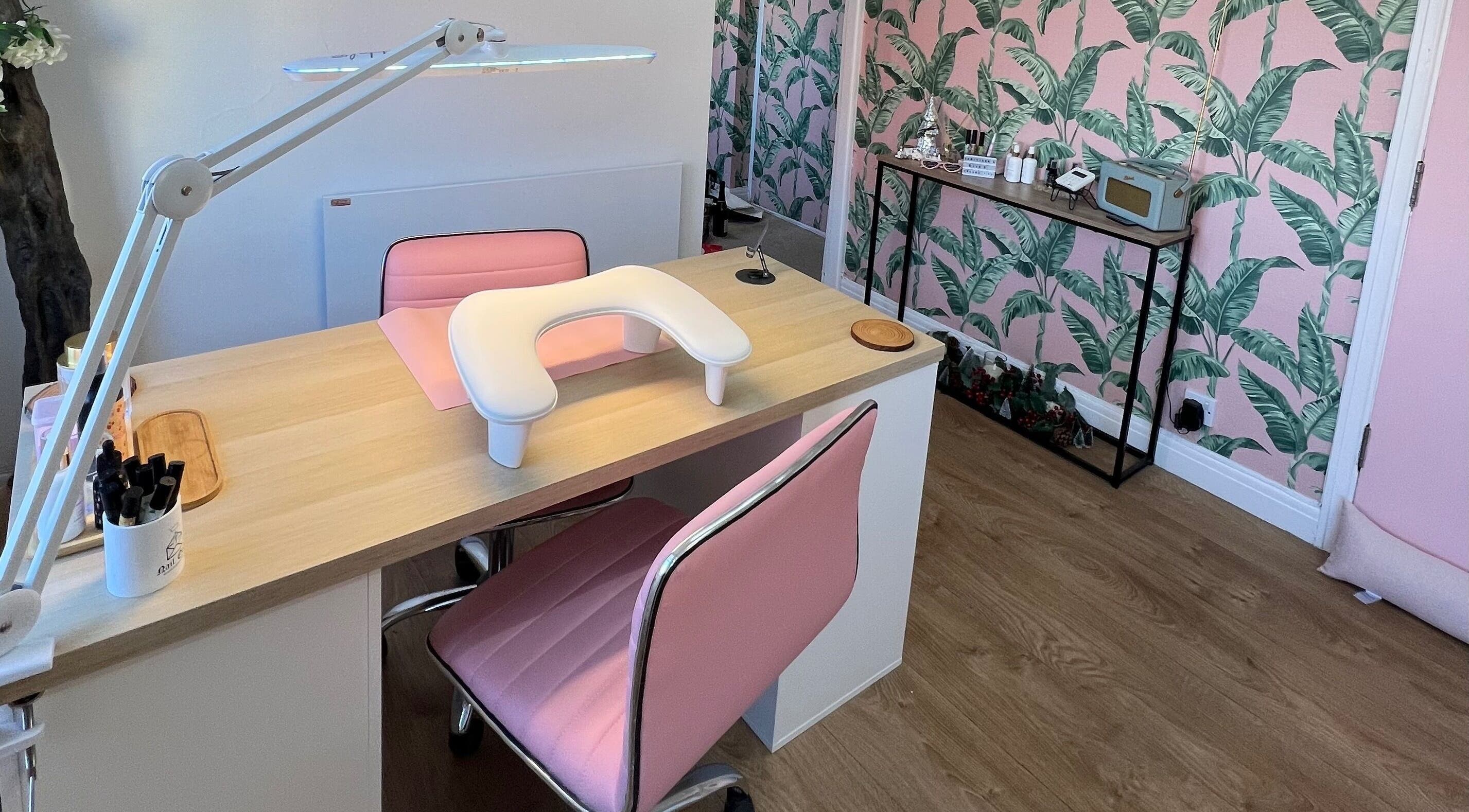 Modern manicure station at Rockets Nails by Vicki, Beverley, England, GB with pink decor and tropical wallpaper.