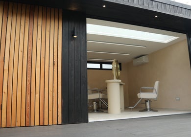 Sleek salon chairs inside District Salon, Southend-on-Sea, England, GB, showcasing modern design with wooden paneling.
