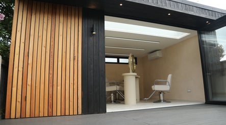 Sleek salon chairs inside District Salon, Southend-on-Sea, England, GB, showcasing modern design with wooden paneling.