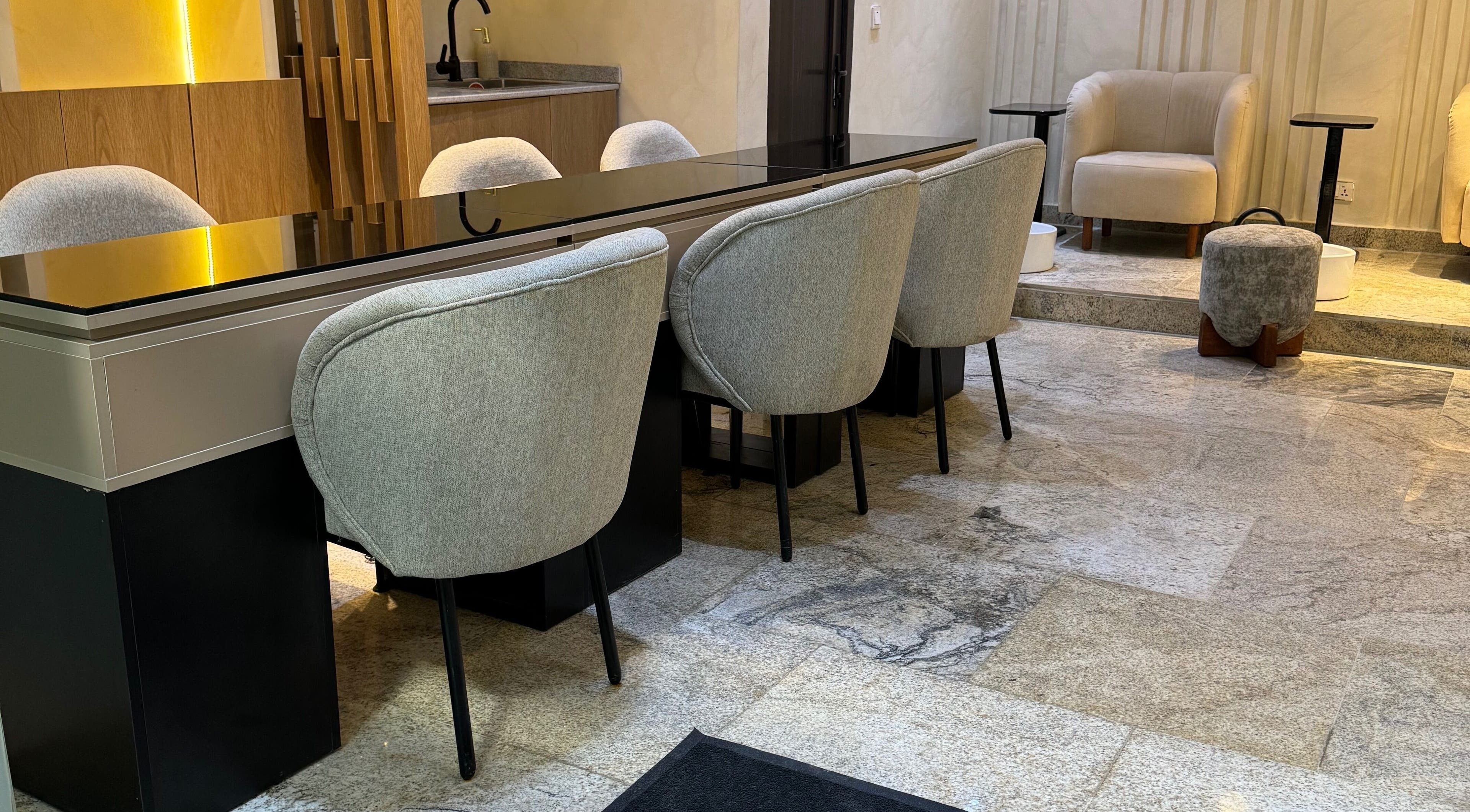 Modern seating area at The Nail Lab, Abuja, Federal Capital Territory, NG, with stylish chairs and sleek decor.