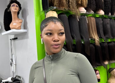 Woman admiring wig display at Freeman Beauty Palace, Johannesburg, Gauteng, ZA.
