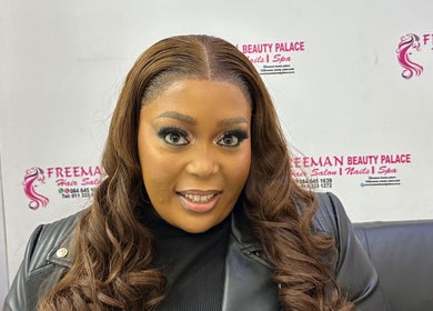 Smiling woman at Freeman Beauty Palace, Johannesburg, Gauteng, ZA, showcasing stylish waves and flawless makeup.