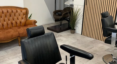 Interno di Verve Men Salon a Selargius, Sardegna, IT, con poltrona moderna e divano vintage.