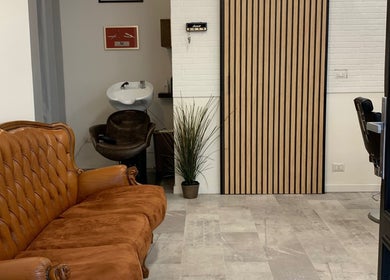 Design raffinato presso Verve Men Salon a Selargius, Sardegna, IT con un elegante divano in pelle.