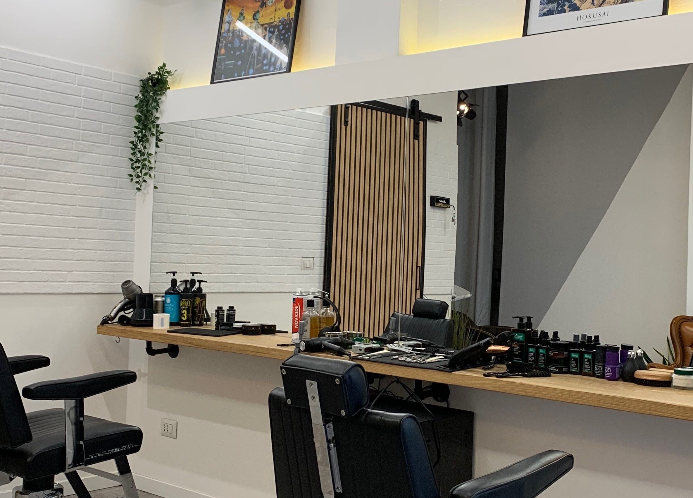 Interno elegante di Verve Men Salon a Selargius, Sardegna, IT con sedie da barbiere e prodotti di lusso.