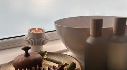 Relaxing spa setup at Neu Beauty Salon, Newport, Wales, GB featuring candle and wooden tools.