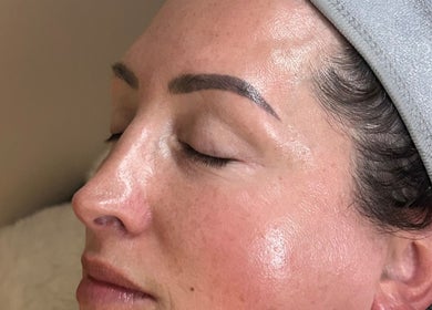 Relaxed woman with glowing skin at Neu Beauty Salon, Newport, Wales, GB, enjoying a rejuvenating facial therapy.