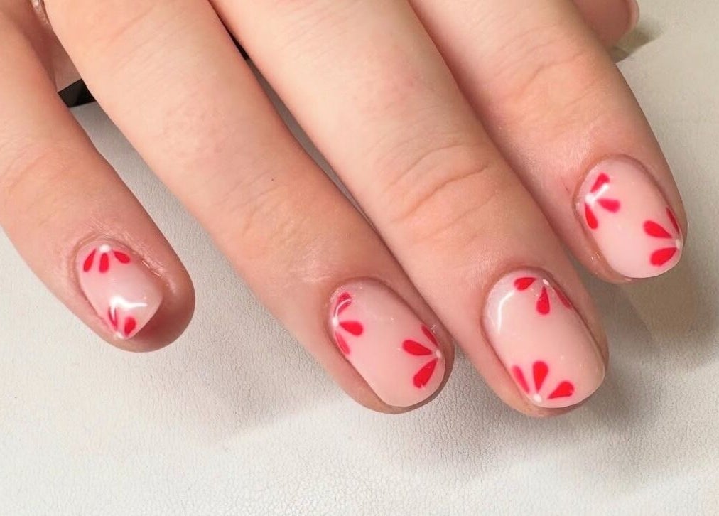 Nail art with red petal design at Nova, Clitheroe, England, GB. Perfect for elegant, striking looks.