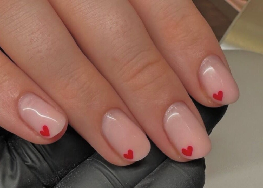 Elegant nail art with red hearts at Nova in Clitheroe, England, GB, showcasing delicate manicure design.