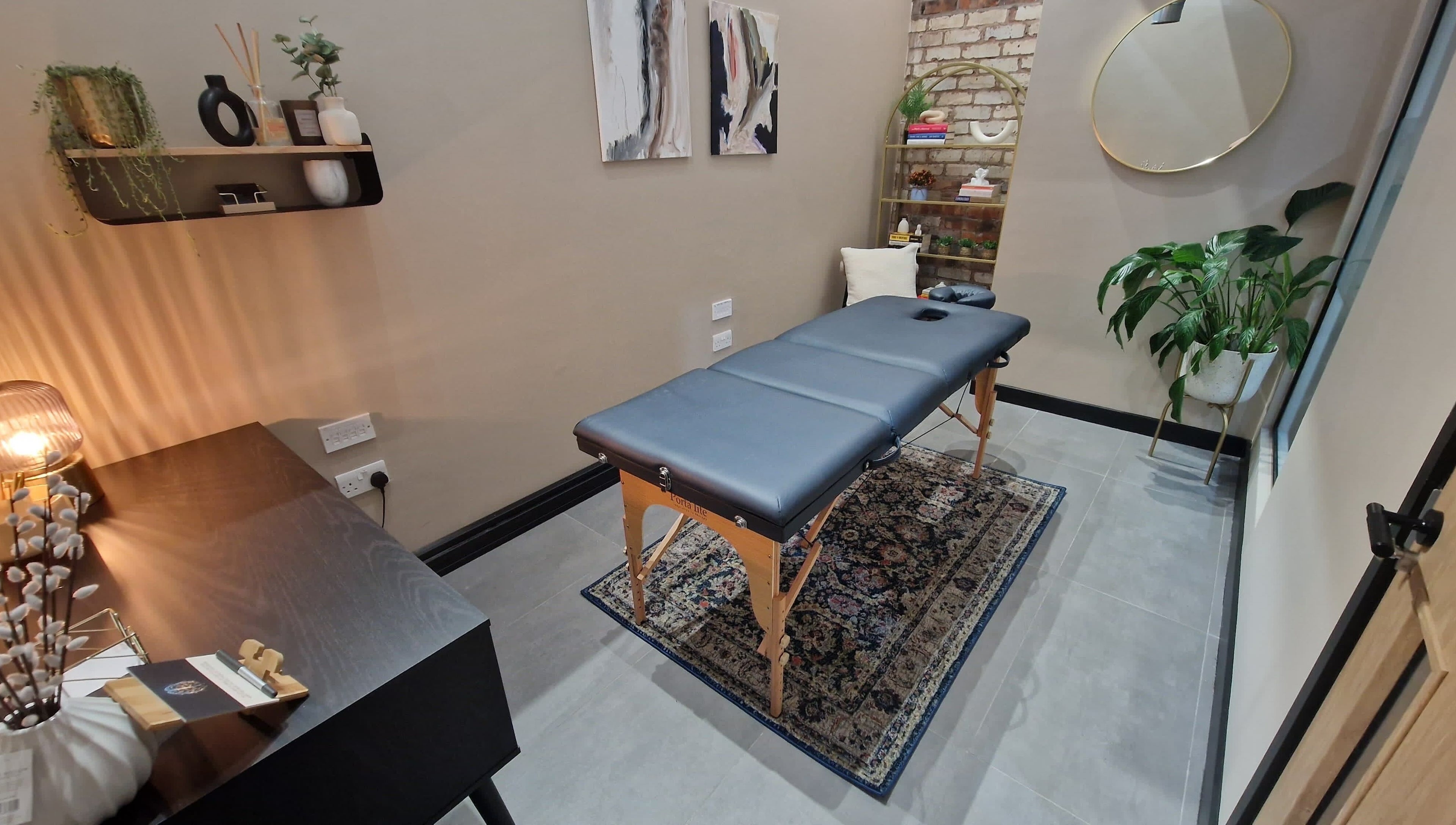 Cozy massage room at Bee Revived, Manchester, England, GB with a massage table and calming decor.