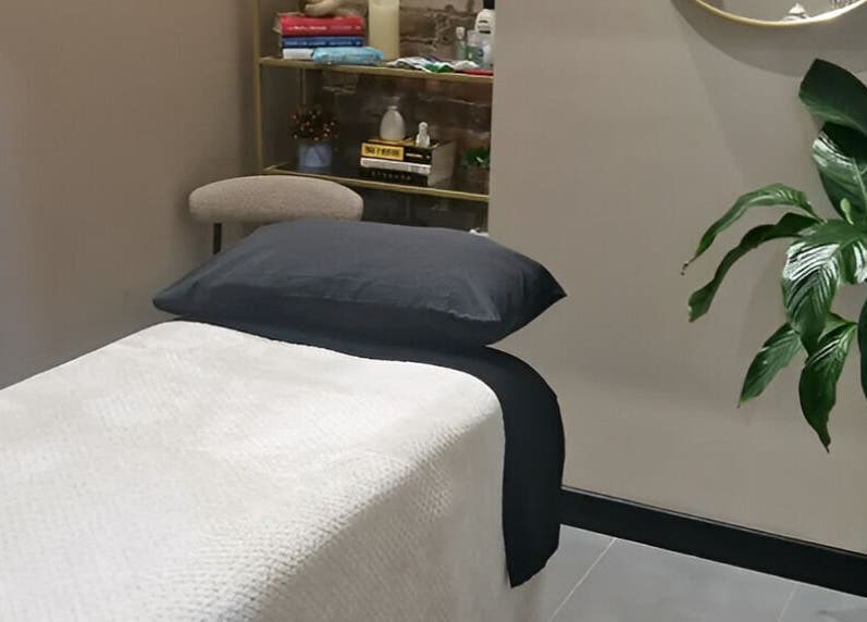 Calming therapy room at Bee Revived, Manchester, England, GB with massage bed and lush plant.