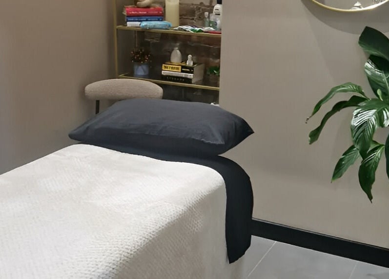 Calming therapy room at Bee Revived, Manchester, England, GB with massage bed and lush plant.