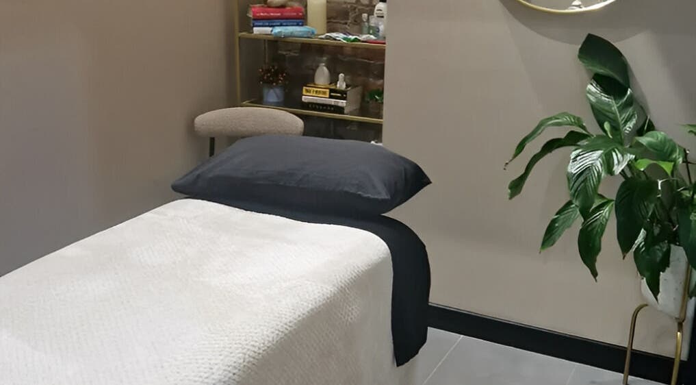 Calming therapy room at Bee Revived, Manchester, England, GB with massage bed and lush plant.