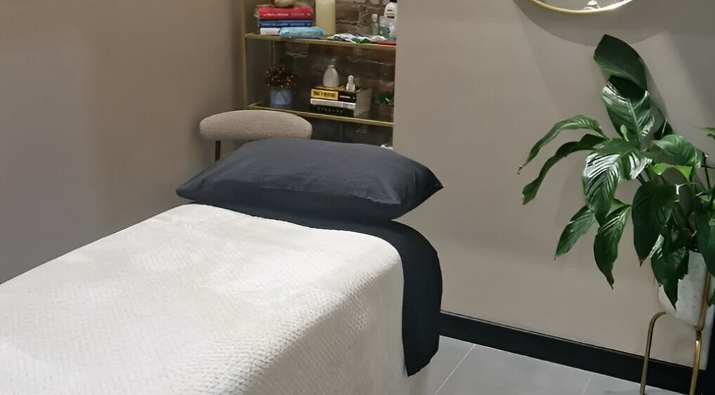 Calming therapy room at Bee Revived, Manchester, England, GB with massage bed and lush plant.