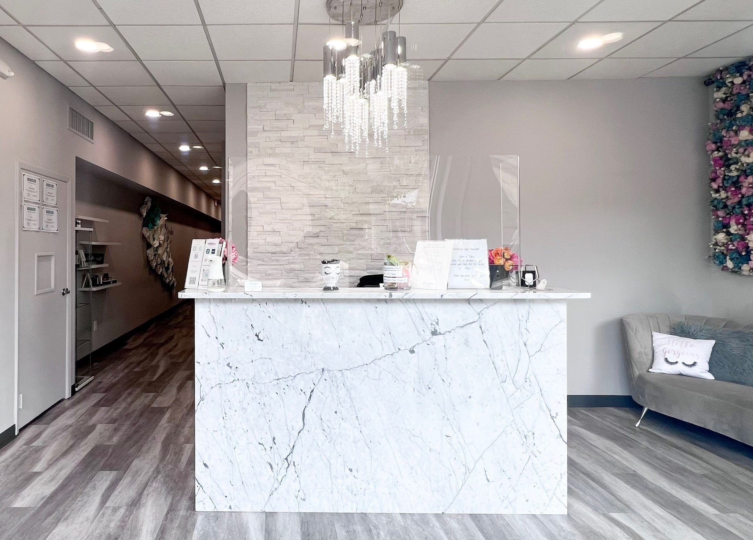 Reception area of Lashes by Katie and Skincare, Bethesda, Maryland, US. Features a marble desk and chic decor.