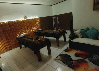 Relaxing spa room at Gili Mo Beauty Spa & Hair Salon, Nusa Tenggara Barat, ID, featuring massage tables and cozy seating.