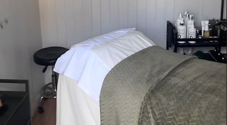 Spa room at Livella Skin in Chester, England featuring a treatment bed with soft linens and skincare products.