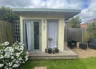 Front view of Livella Skin's cozy garden studio in Chester, England, GB, with seating area and lush greenery.