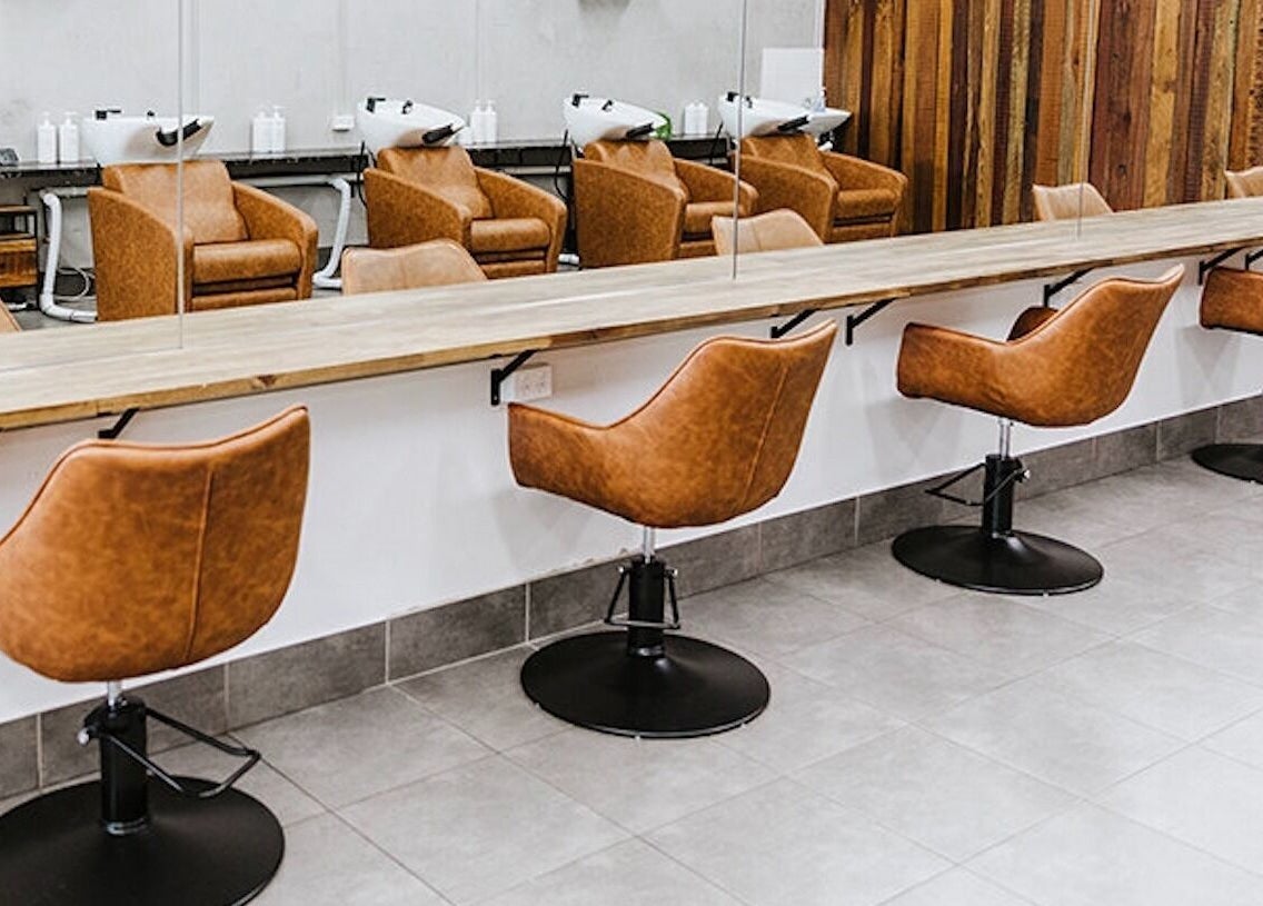 Elegant styling stations at Soho Hair Salon in Narellan, New South Wales, AU, featuring modern leather chairs.