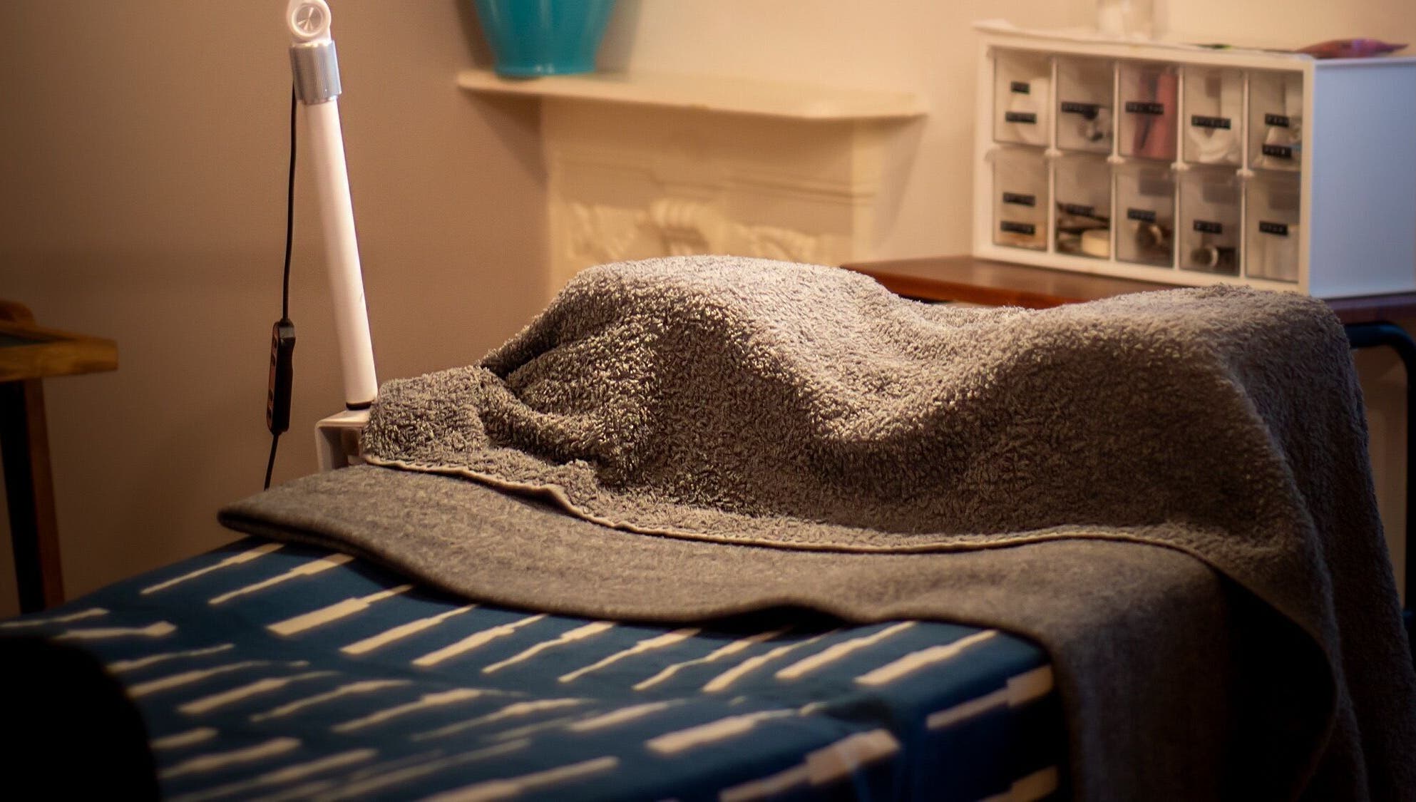 A relaxing treatment bed with cozy towels at Kanti Studio in Colwick, England, GB.