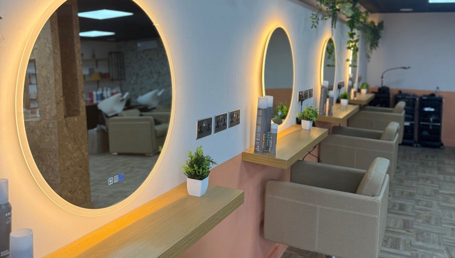Elegant salon interior at Preston & Co Hairdressing, Clayton-le-woods, England, GB with chic round mirrors and greenery.