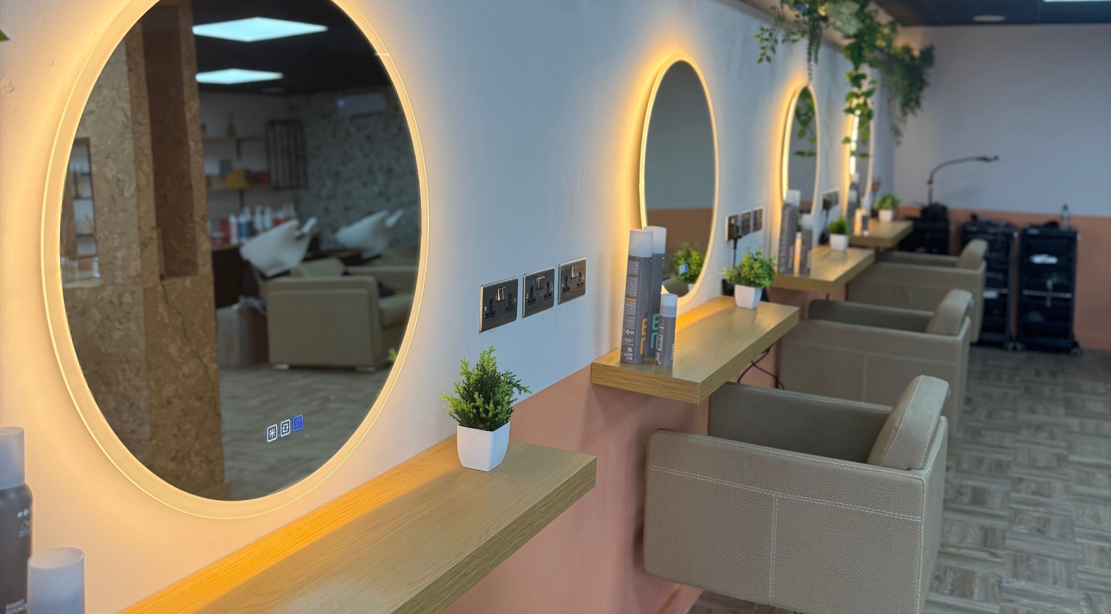 Elegant salon interior at Preston & Co Hairdressing, Clayton-le-woods, England, GB with chic round mirrors and greenery.