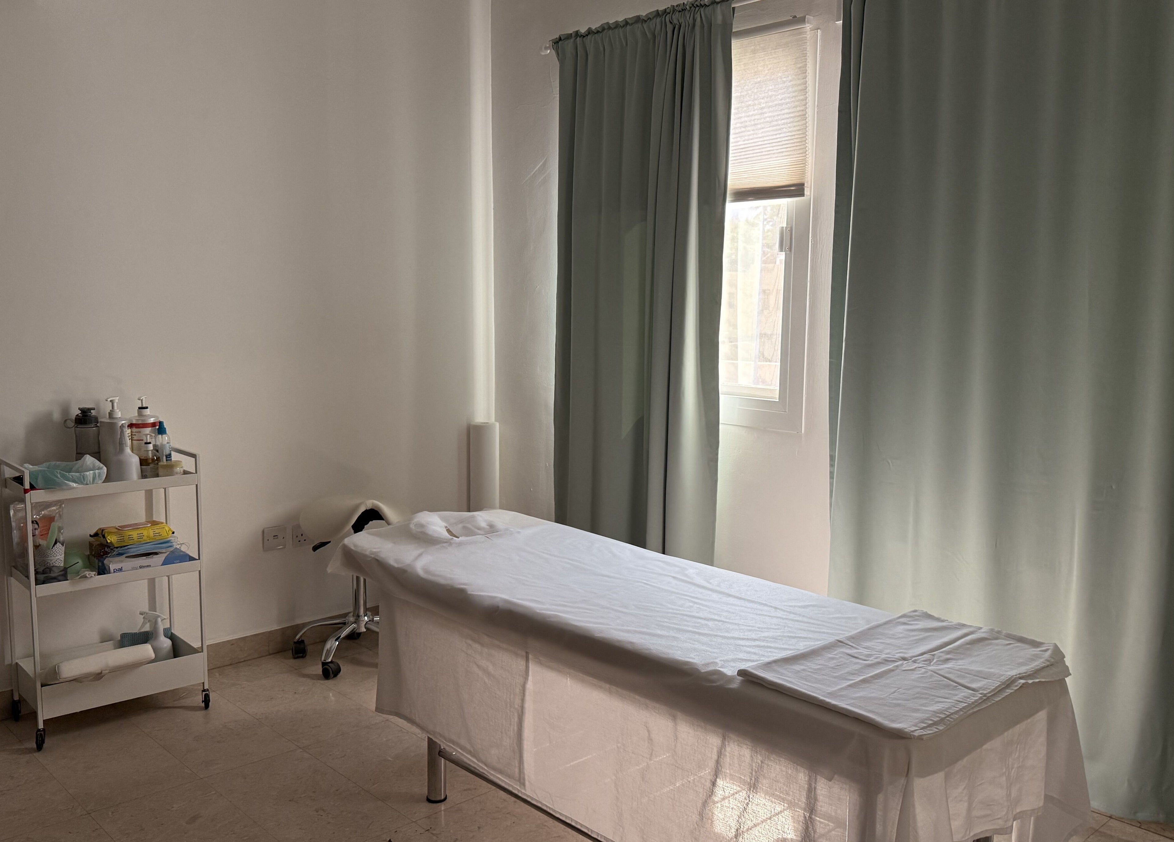 Calm treatment room at Sculptor by Aray Kairkanova, Muscat, with massage table and wellness essentials.