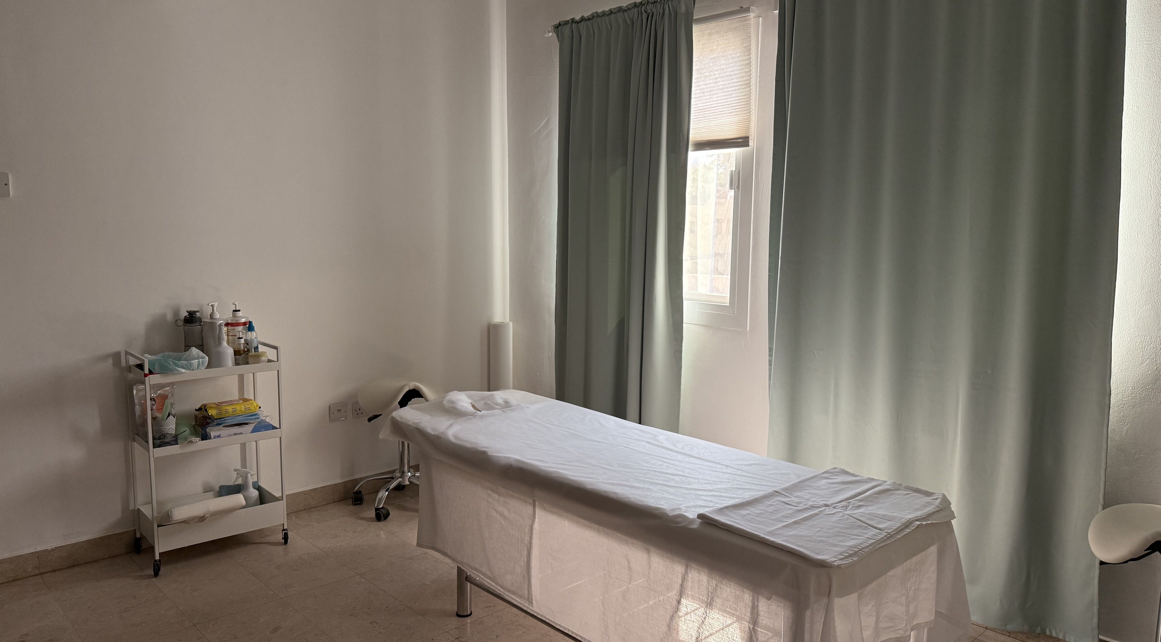 Calm treatment room at Sculptor by Aray Kairkanova, Muscat, with massage table and wellness essentials.