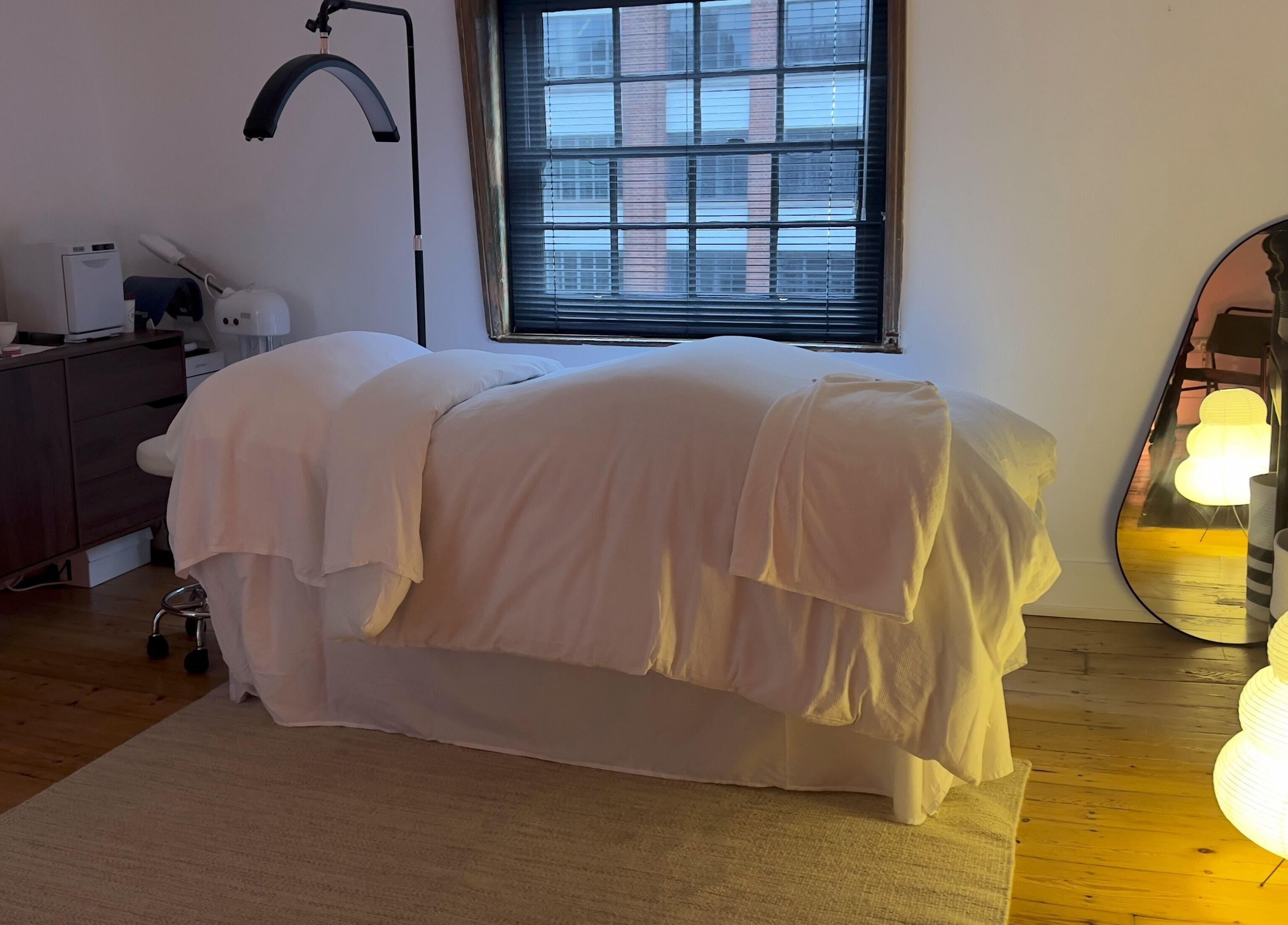 Serene treatment room at House of Kush-Kush, London, GB with cozy massage bed and warm lighting.