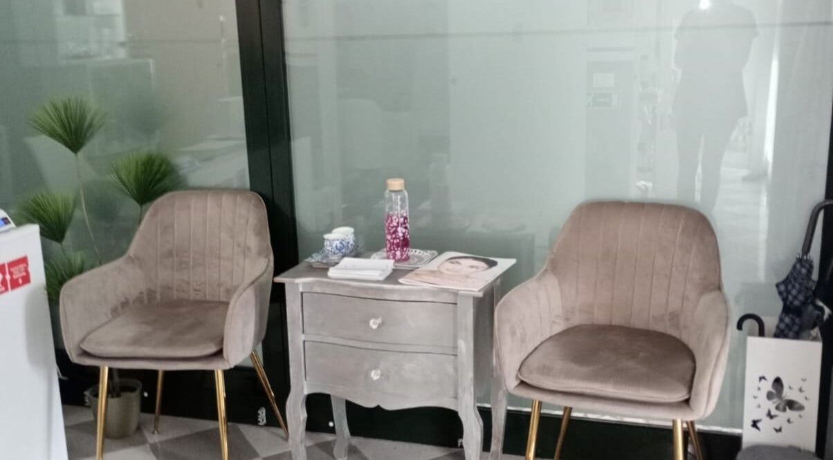 Zona d'attesa elegante presso Estetica il volo, Padova, Veneto, IT con poltrone e tavolino raffinati.