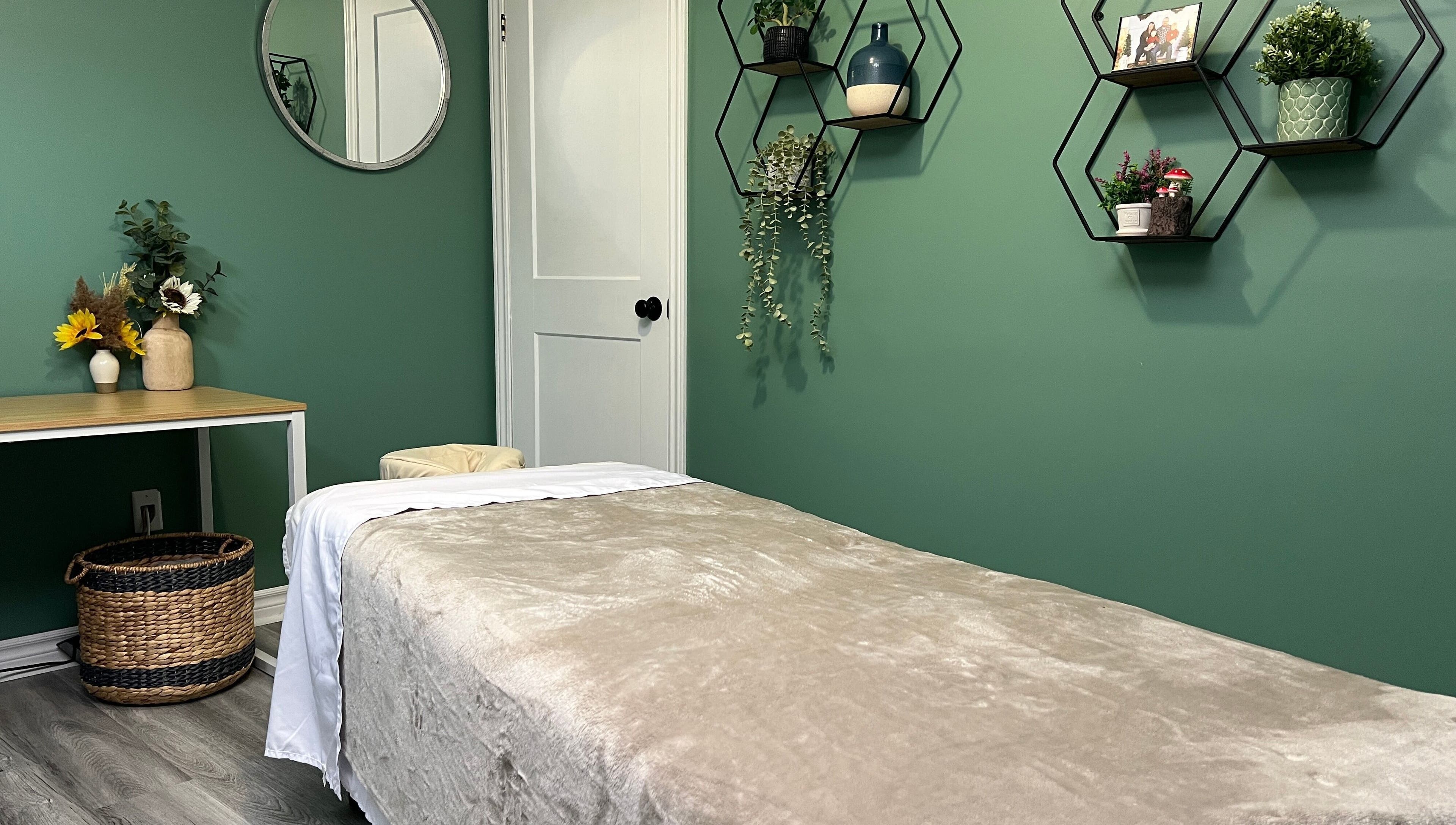 Cozy massage room at Shawna Stemmler RMT in Kitchener, Ontario, CA with green decor and calming ambiance.