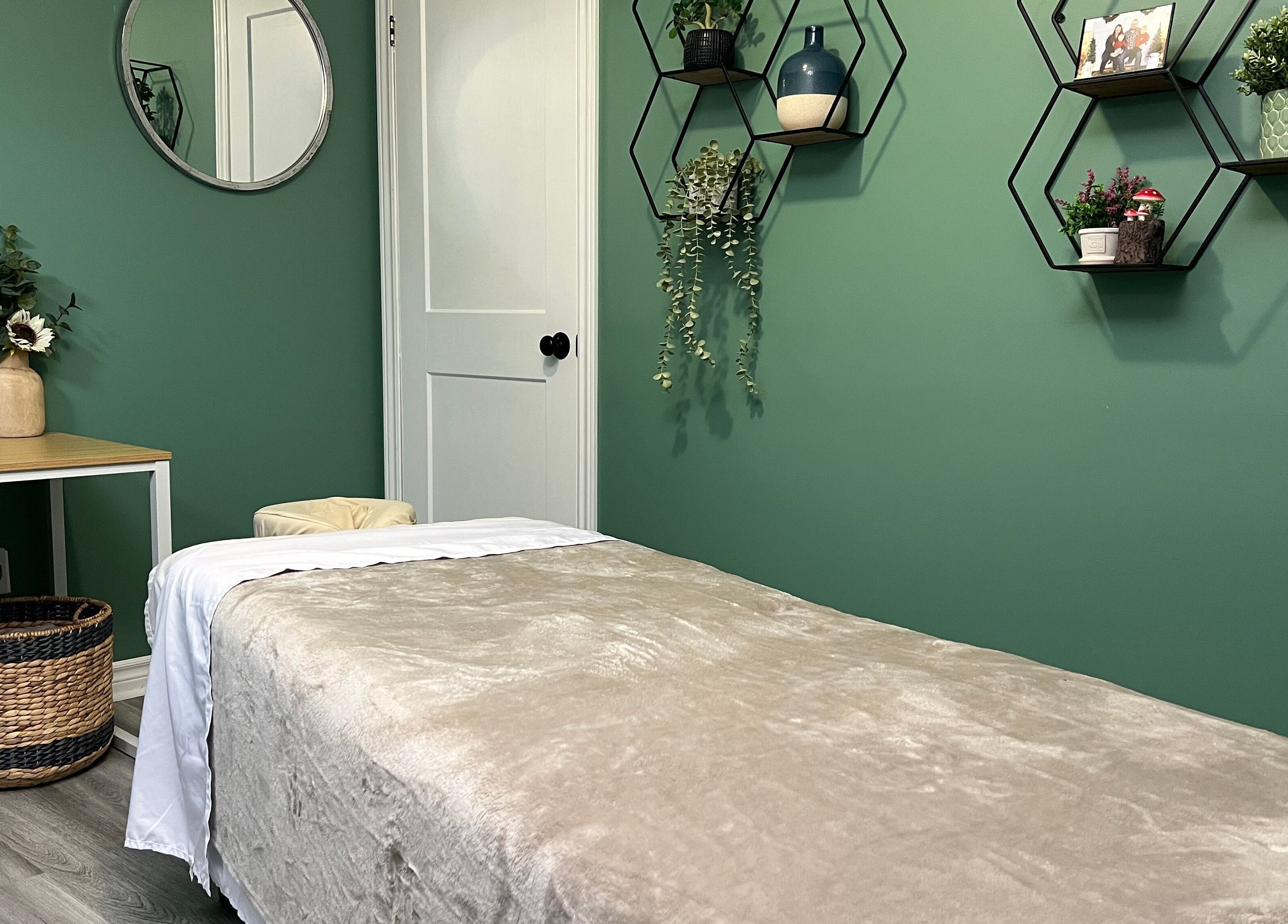 Cozy massage room at Shawna Stemmler RMT in Kitchener, Ontario, CA with green decor and calming ambiance.