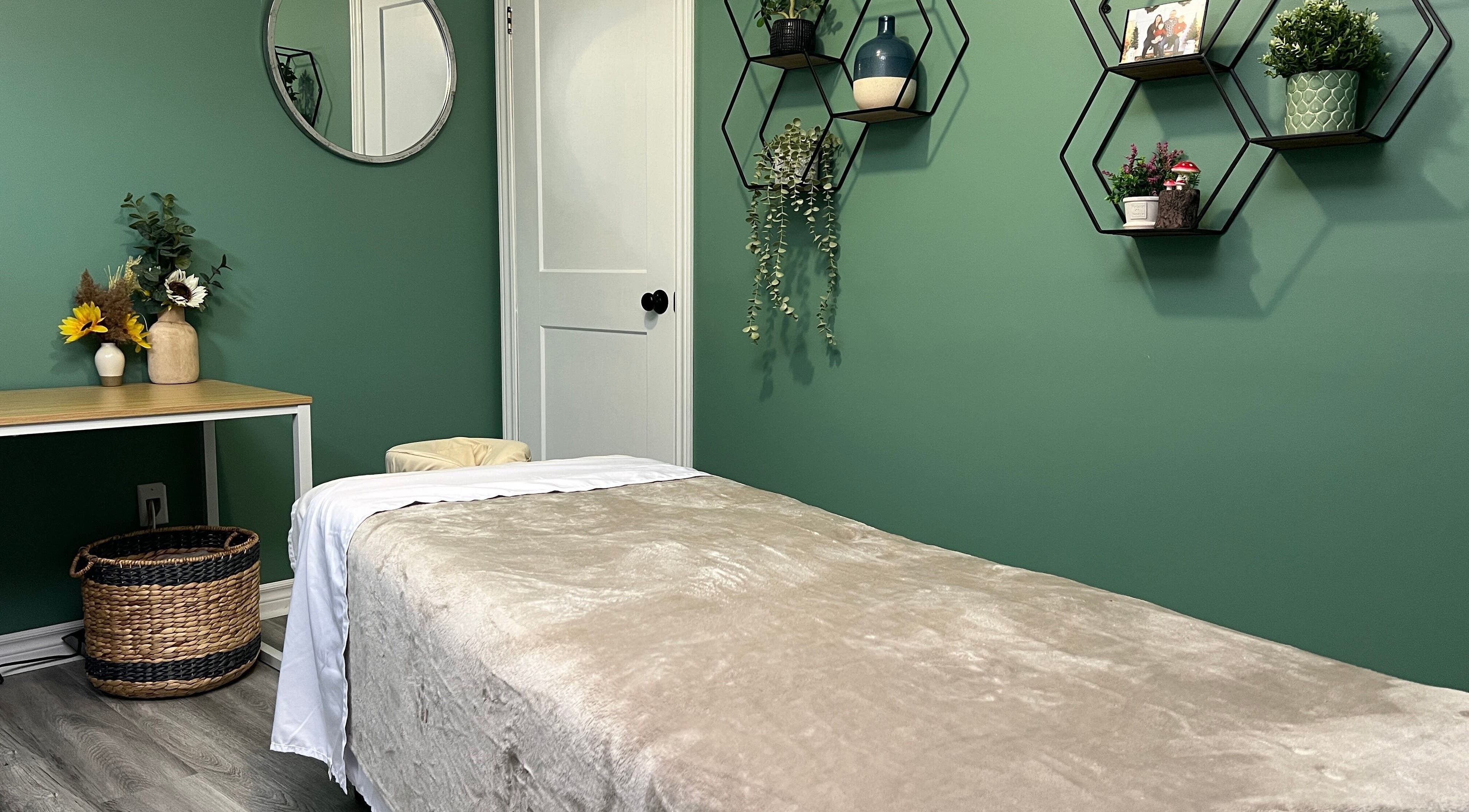 Cozy massage room at Shawna Stemmler RMT in Kitchener, Ontario, CA with green decor and calming ambiance.