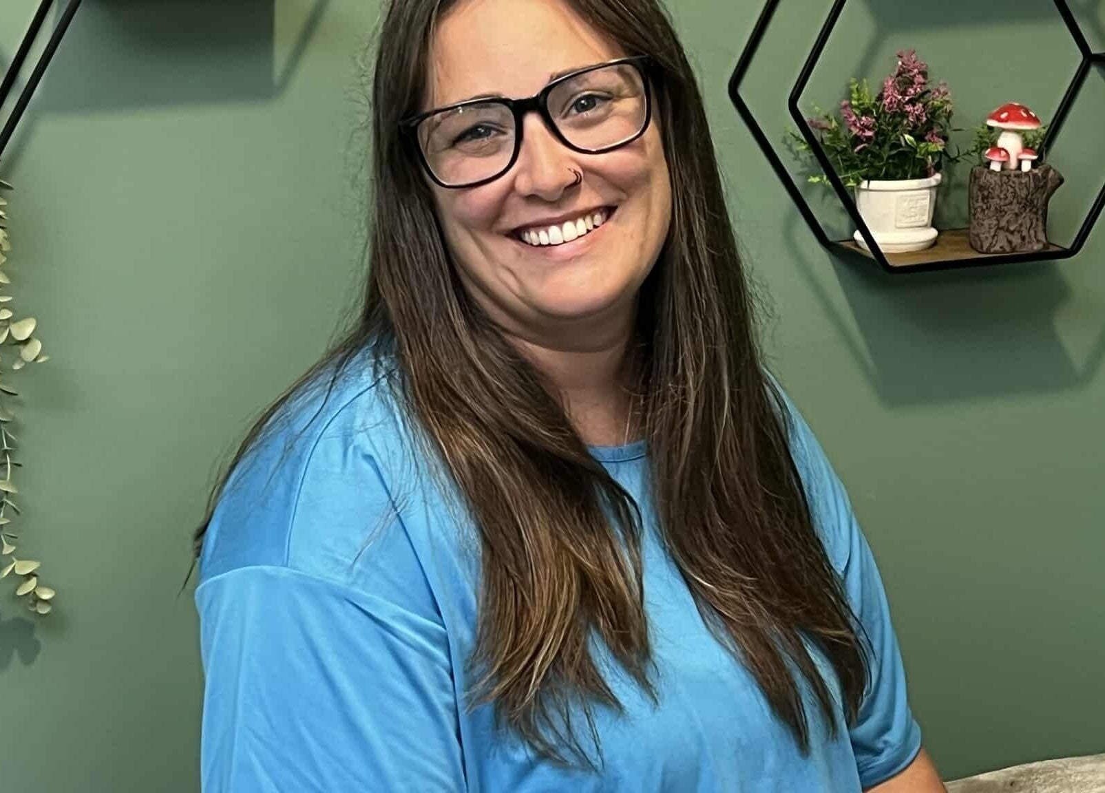 Smiling individual at Shawna Stemmler RMT, Kitchener, Ontario, CA with decor in the background.