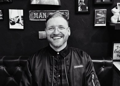 Smiling man at LapsaBarber\M.Nometņu iela 45A, Rīga, LV, showcasing barbershop ambiance.