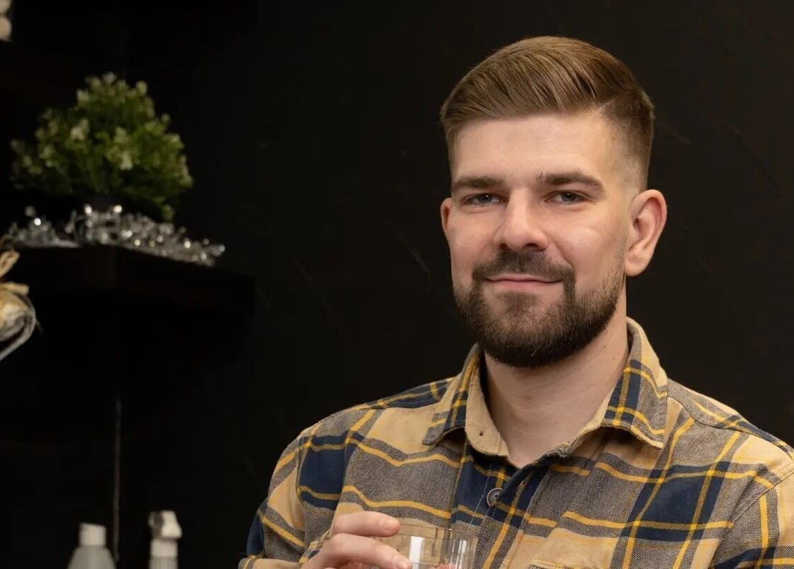 Smiling man at LapsaBarber\M.Nometņu iela 45A, Rīga, LV, with stylish haircut and cozy atmosphere.