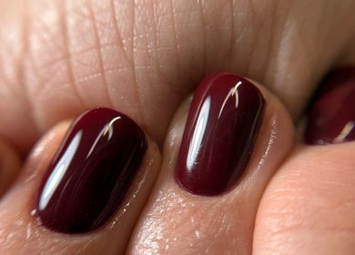 Stylish dark red manicure by Ana Fernandes, Dublin 01, IE, showcasing glossy nail finish.