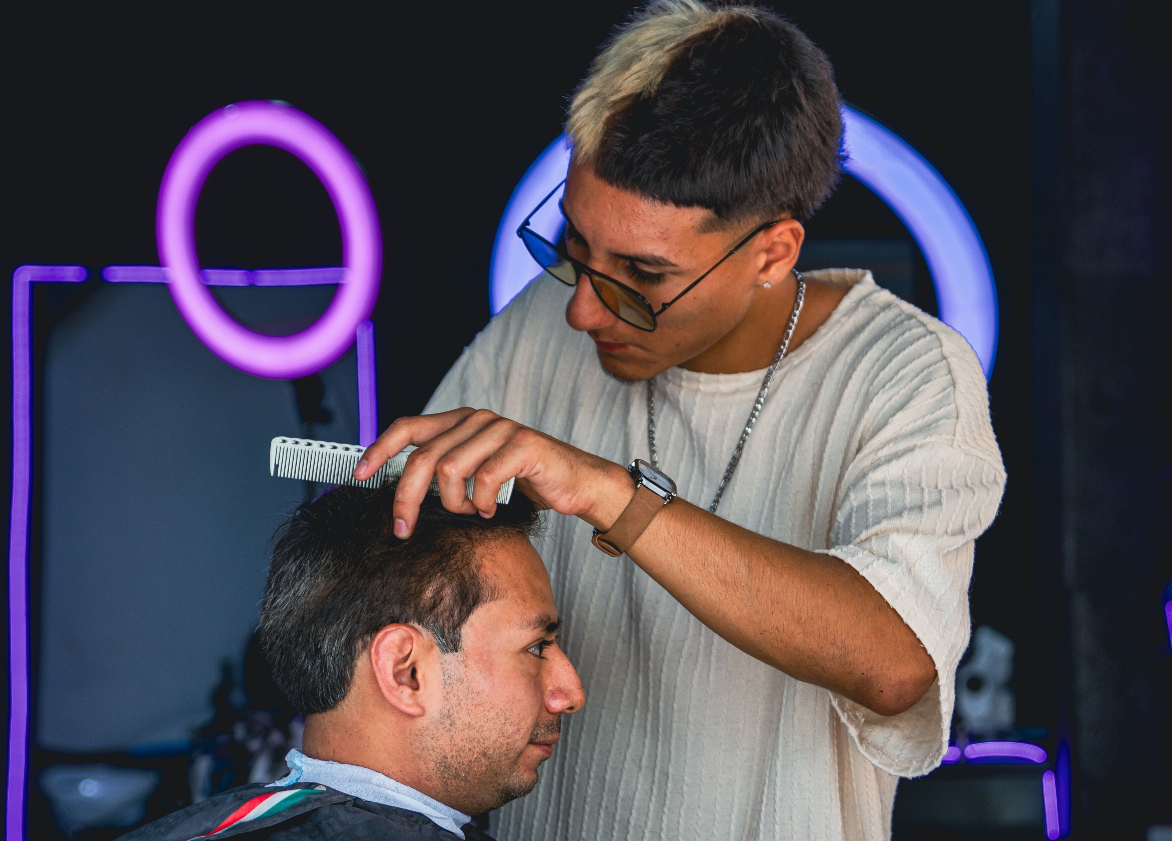 Barber at Barberia Mercurio in Zapopan, Jalisco, MX expertly trims a client's hair.